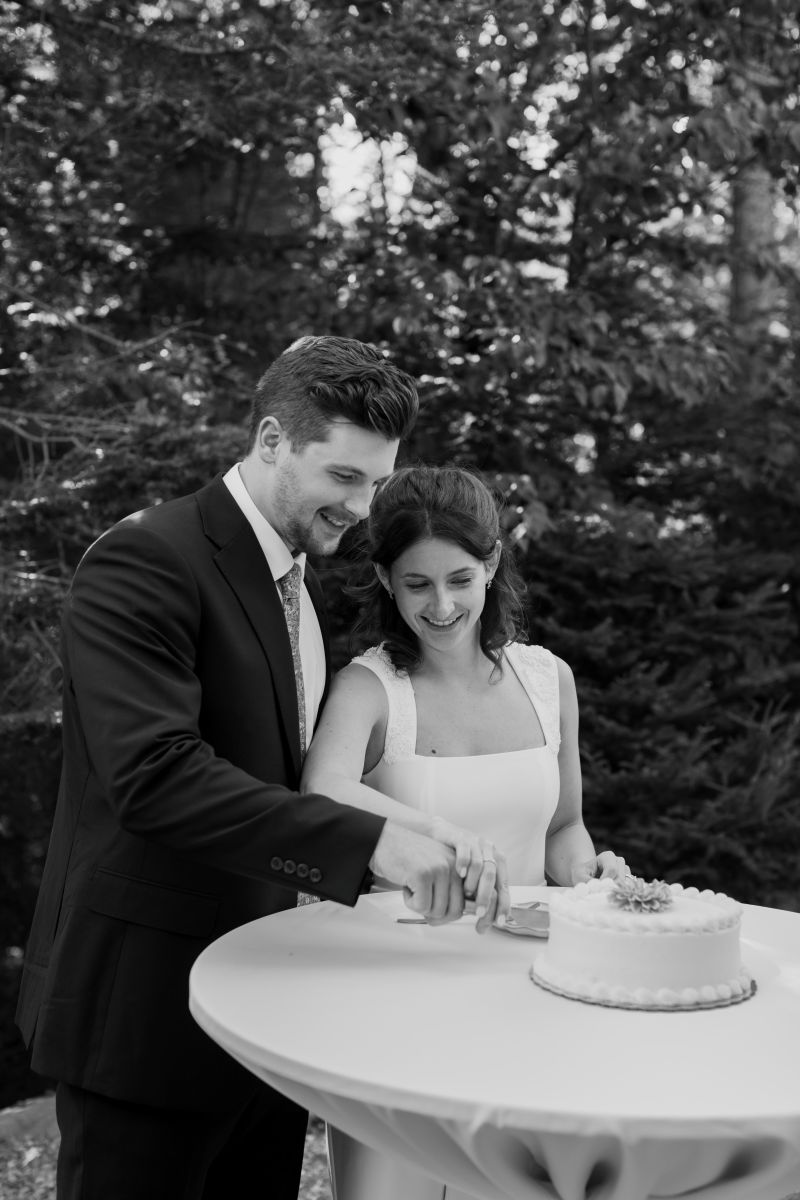 a couple cutting their wedding cake during their backyard wedding ceremony