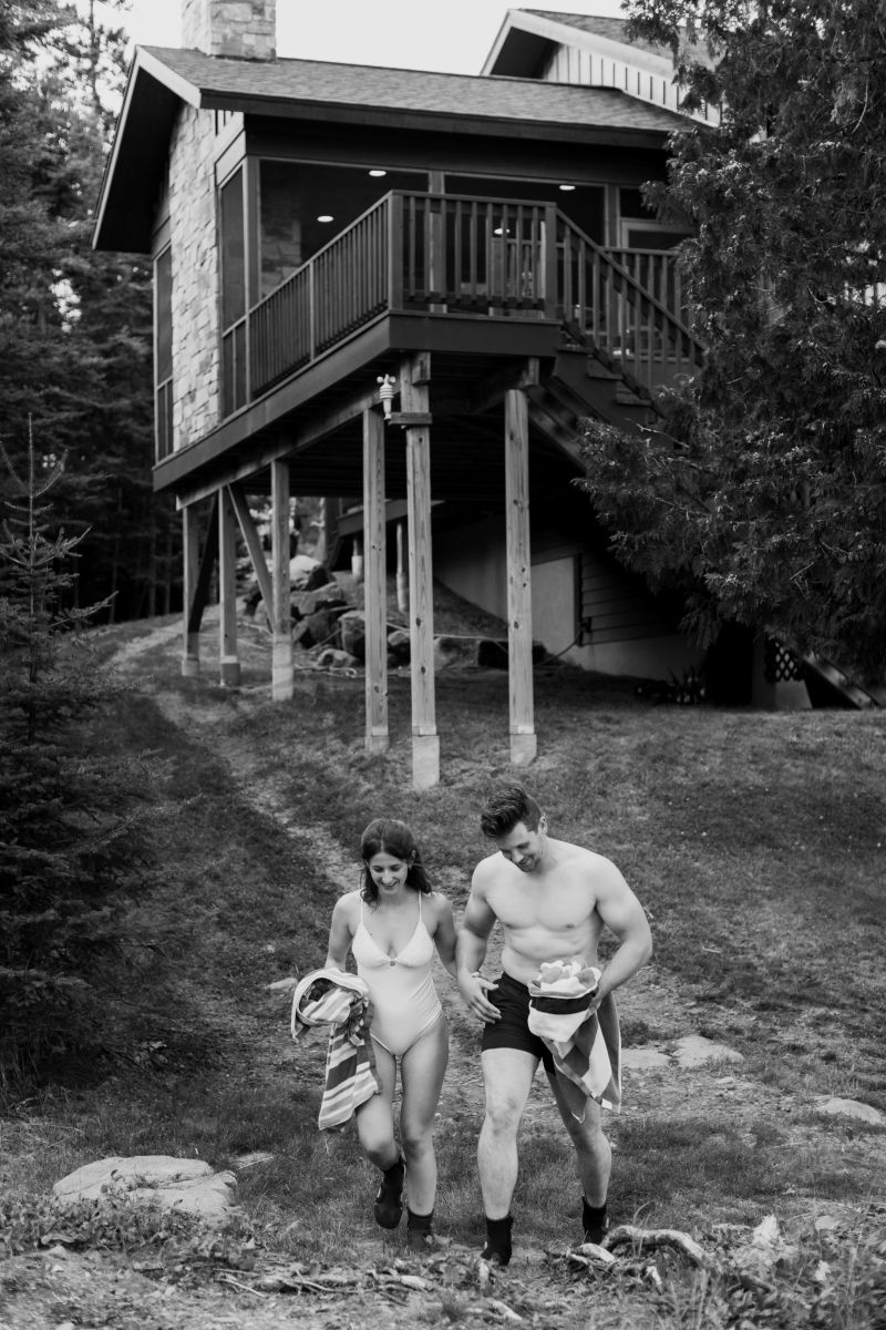 a couple wearing swimsuits getting ready to jump in the lake 