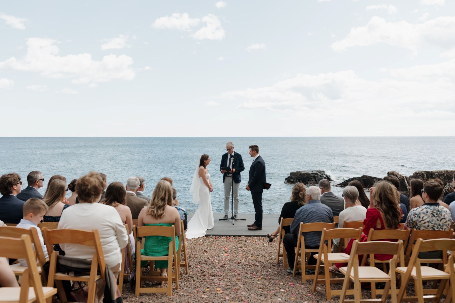a couple having their wedding ceremony next to the water in Grand Marais, Minnesota