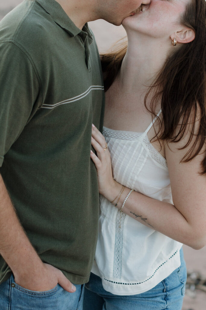 A couple leaning into each other as they kiss 