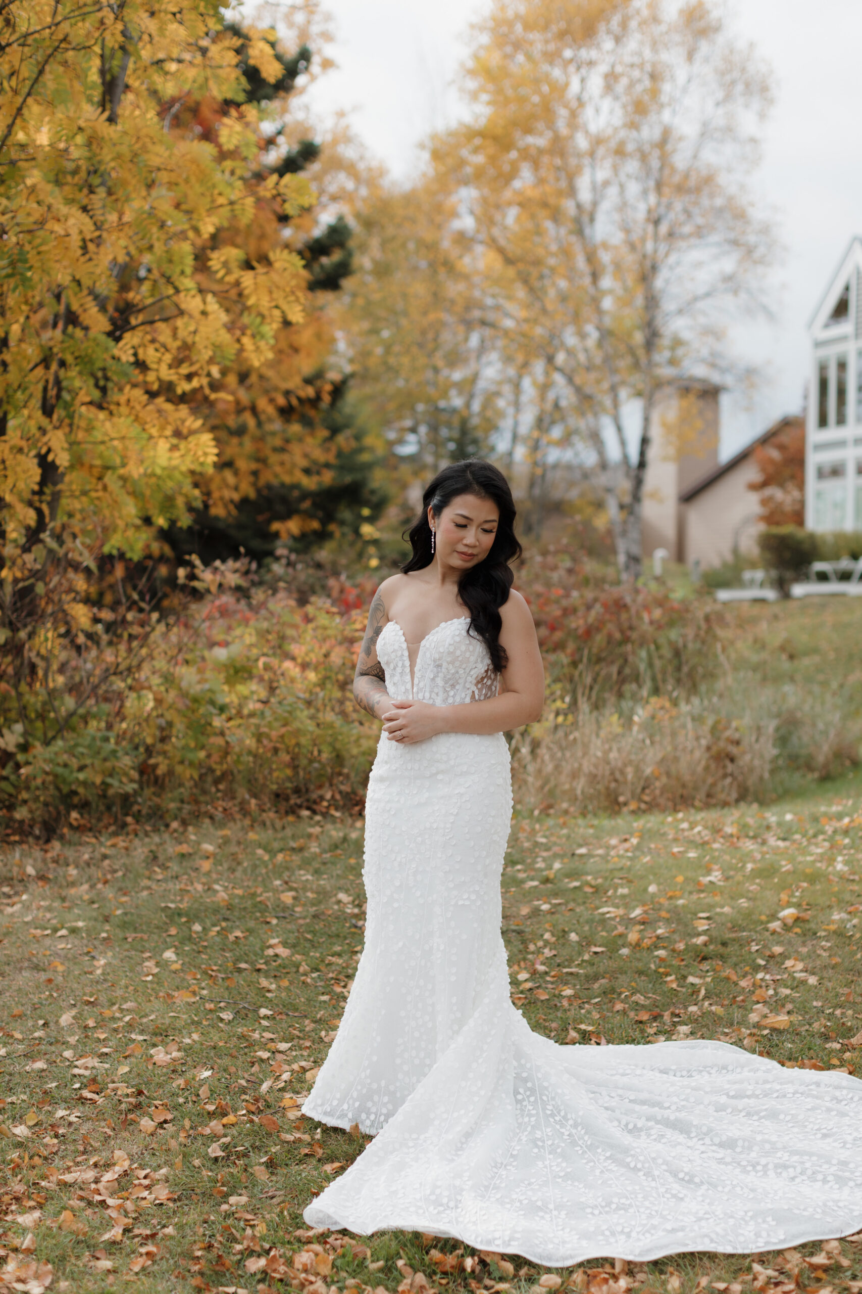 a woman standing in the grass taking wedding portraits at bluefin bay in tofte mn 