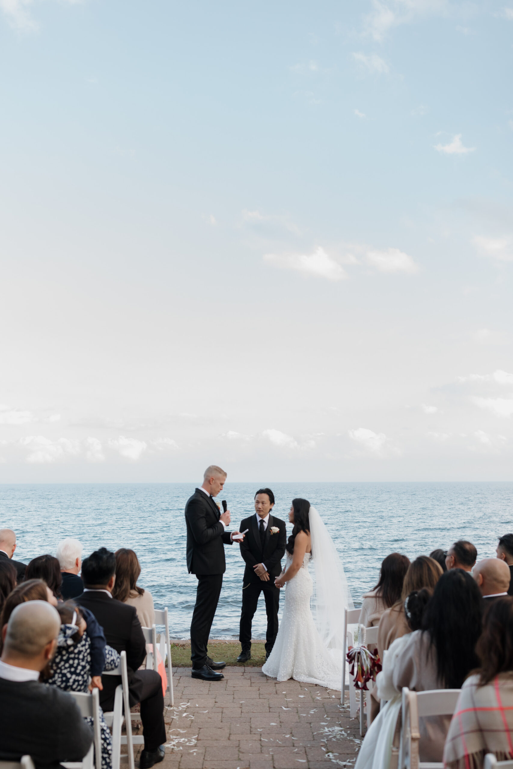 a couple having their wedding ceremony next to lake superior at bluefin bay in tofte mn 