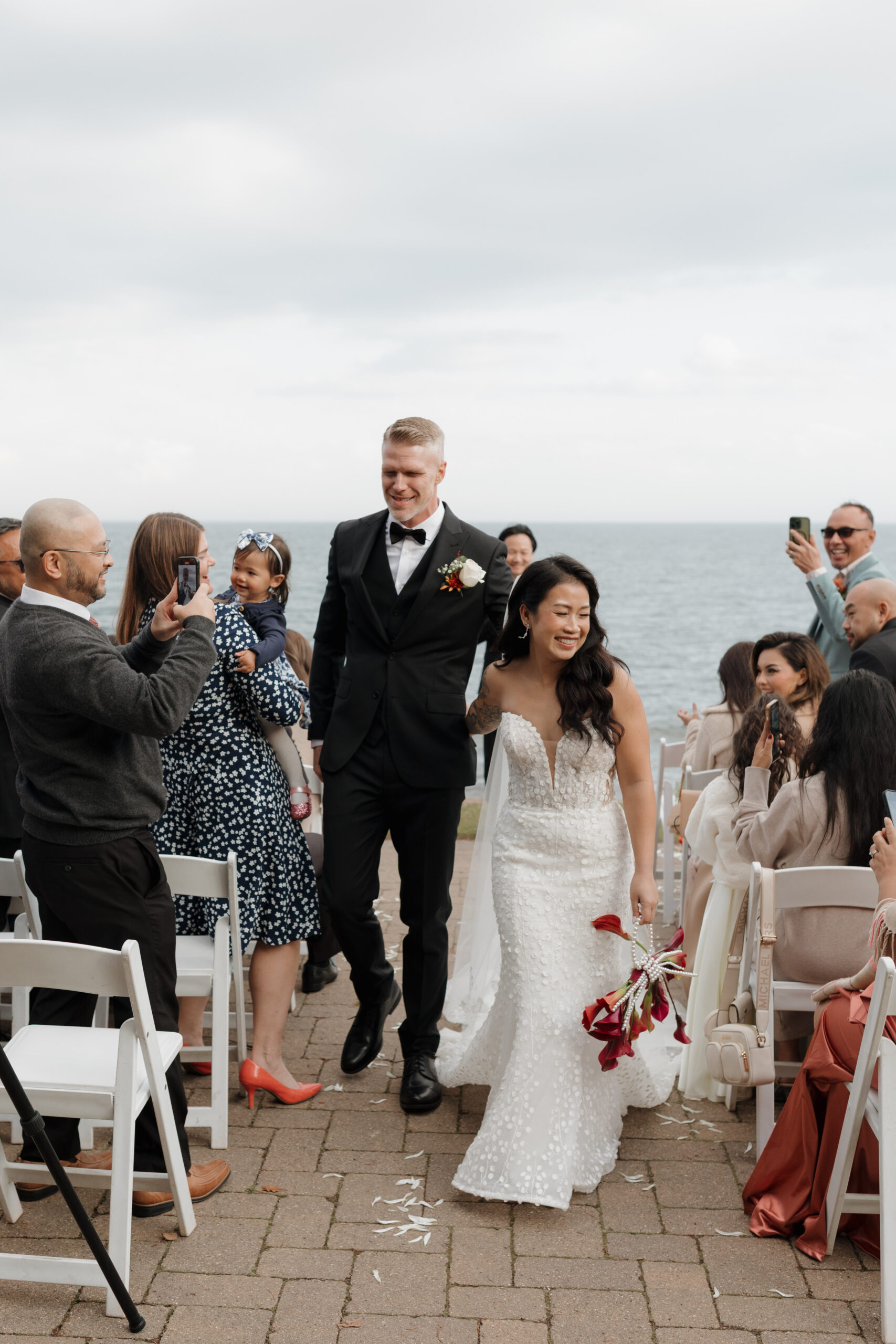 a couple walking hand in hand together after their wedding ceremony at bluefin bay in tofte mn 
